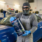 Lack Depot technician in protective gear holding a 5L container of LD Waschverdünnung solvent in a workshop.